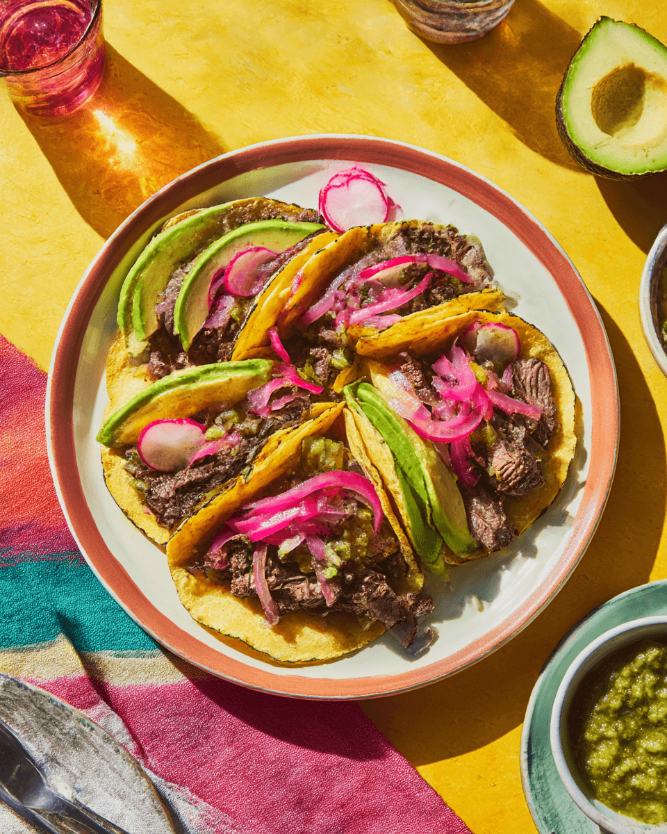 skirt-steak-tacos-serving. skirt steak tacos served with avocado and salsa