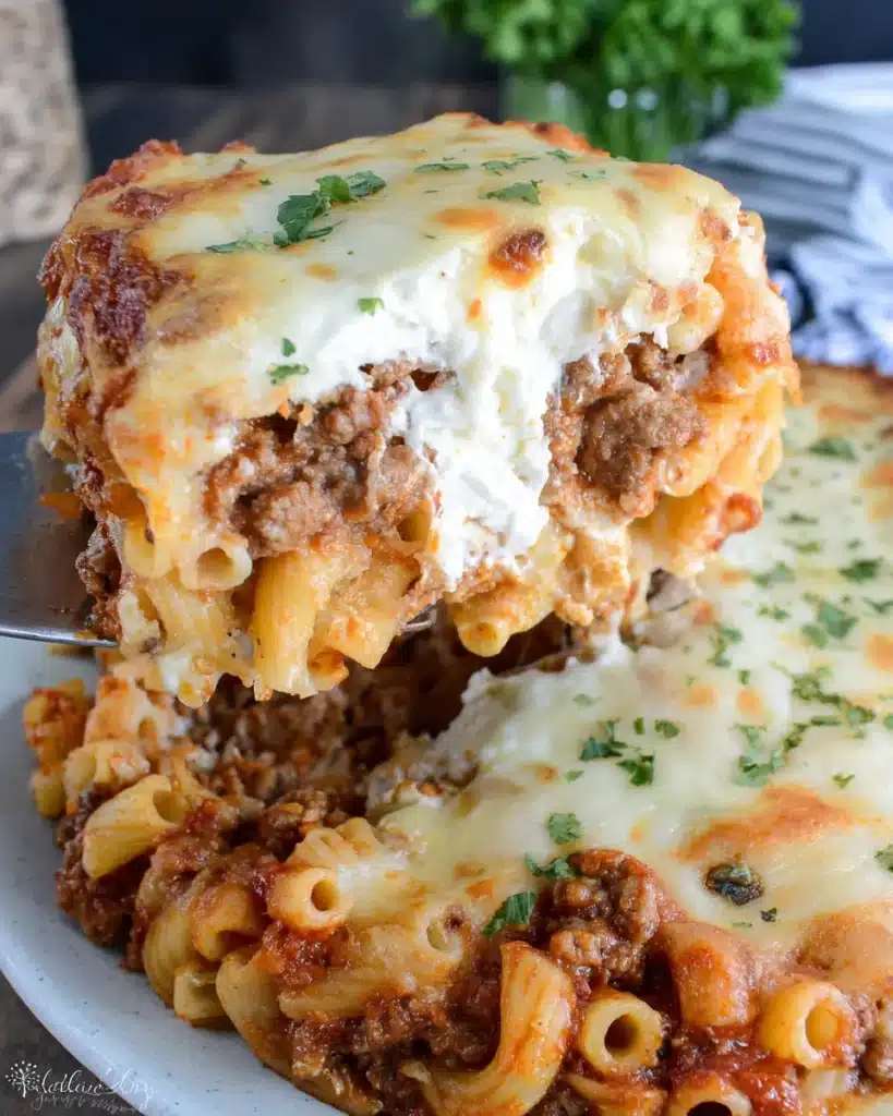 Close-up of baked ziti with ricotta cheese lifted on spatula.