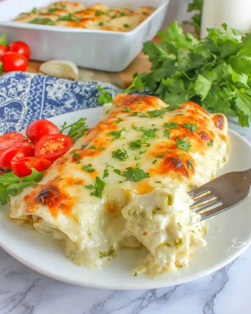 Creamy chicken enchiladas on a white plate with golden melted cheese