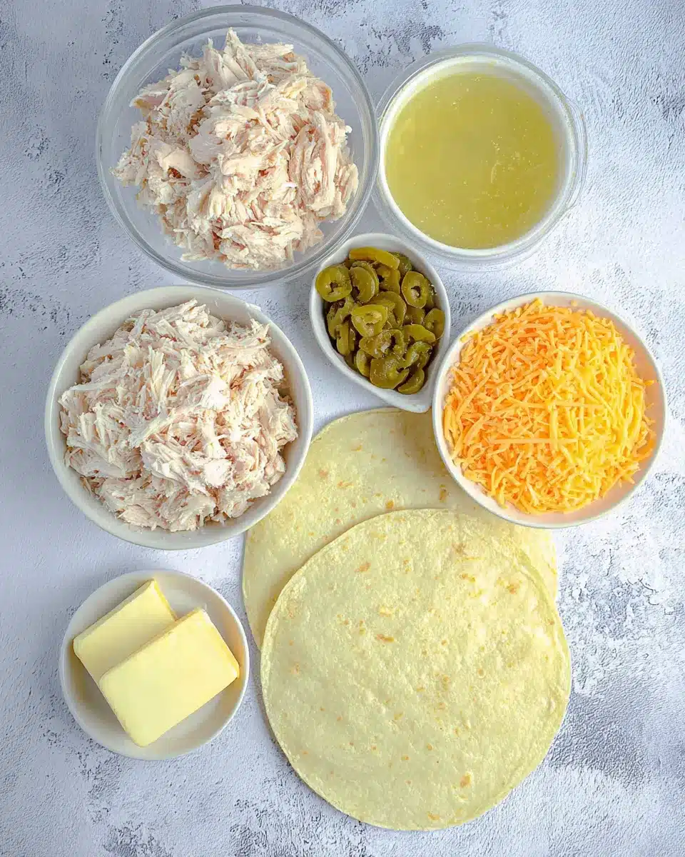 Flat lay of creamy chicken enchiladas ingredients on a marble surface